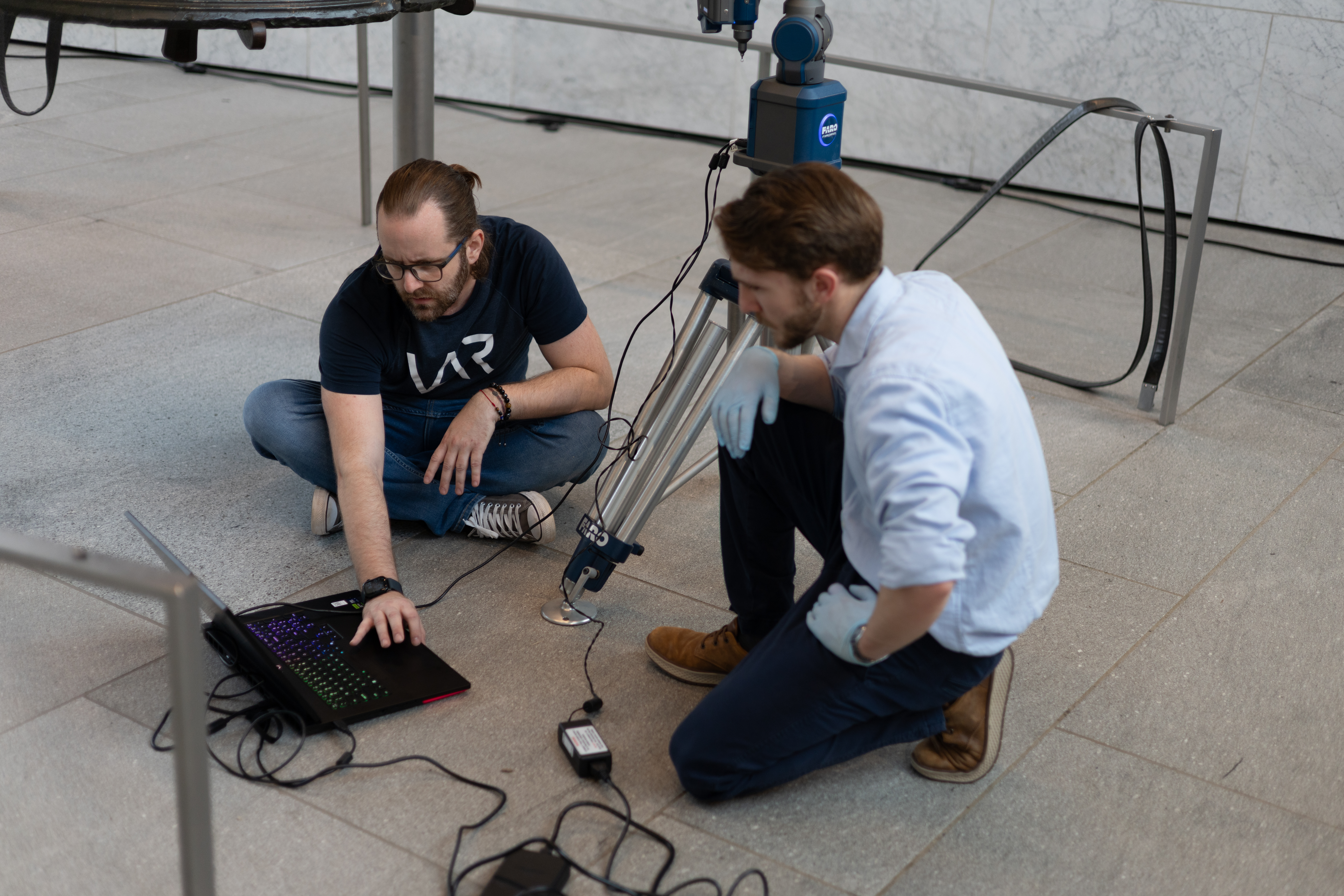 Team members reviewing Liberty Bell scan data beside the FARO arm